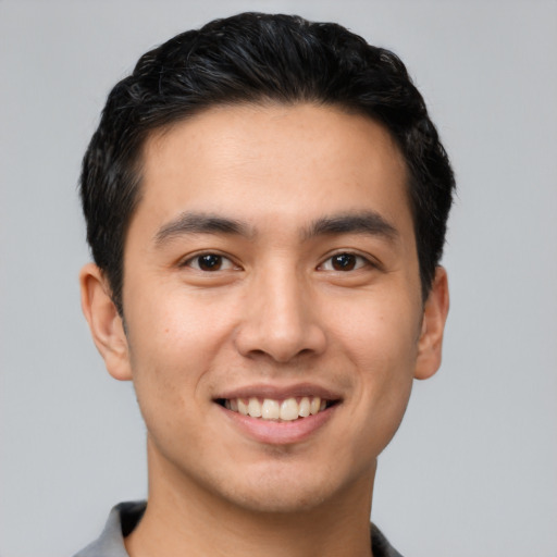 Joyful asian young-adult male with short  brown hair and brown eyes