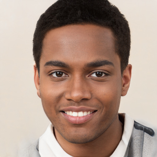 Joyful black young-adult male with short  brown hair and brown eyes