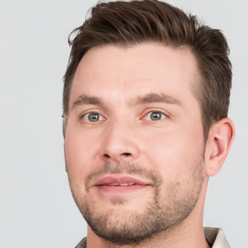 Joyful white young-adult male with short  brown hair and grey eyes