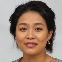 Joyful asian adult female with medium  brown hair and brown eyes