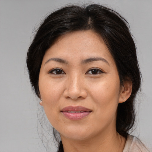 Joyful asian adult female with medium  brown hair and brown eyes