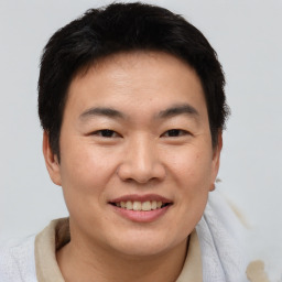 Joyful asian young-adult male with short  brown hair and brown eyes