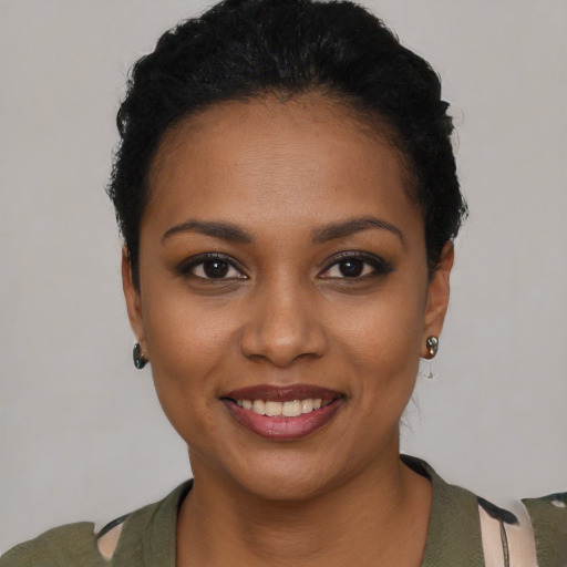 Joyful black young-adult female with short  black hair and brown eyes
