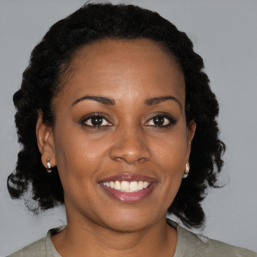 Joyful black young-adult female with medium  brown hair and brown eyes