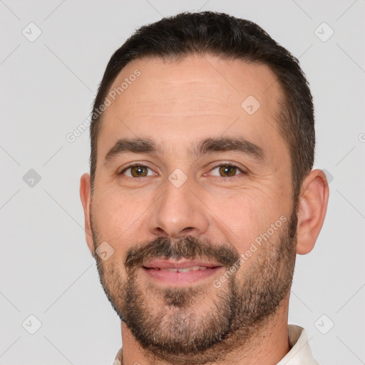 Joyful white adult male with short  brown hair and brown eyes