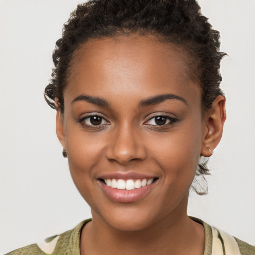 Joyful black young-adult female with short  brown hair and brown eyes