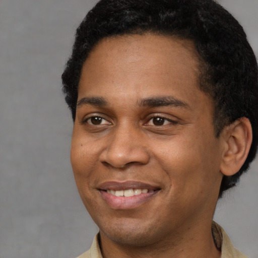 Joyful latino young-adult male with short  black hair and brown eyes