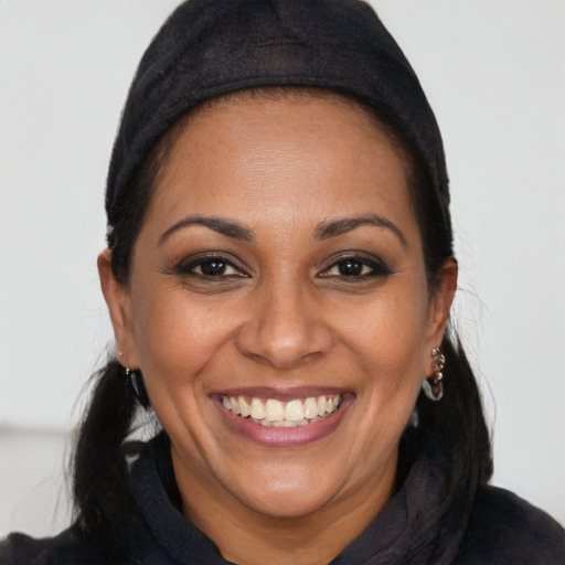 Joyful black adult female with long  brown hair and brown eyes