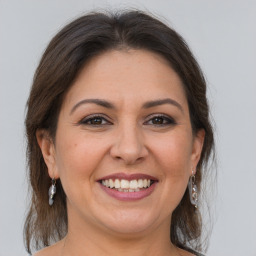 Joyful white adult female with medium  brown hair and grey eyes