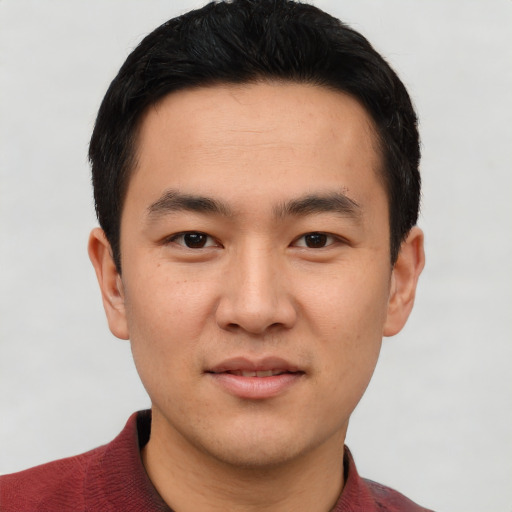Joyful asian young-adult male with short  black hair and brown eyes