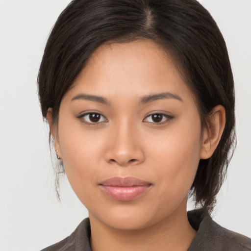 Joyful latino young-adult female with medium  brown hair and brown eyes