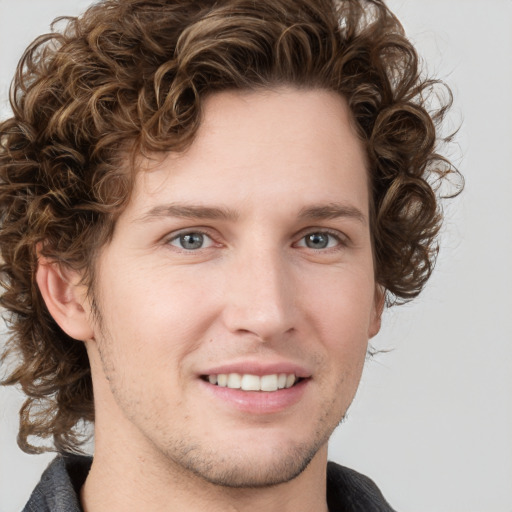 Joyful white young-adult male with medium  brown hair and grey eyes