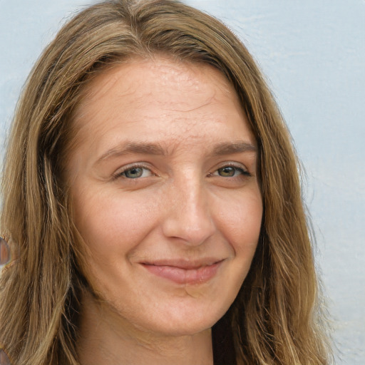 Joyful white adult female with long  brown hair and green eyes