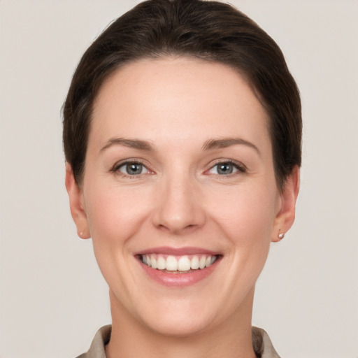 Joyful white young-adult female with short  brown hair and grey eyes