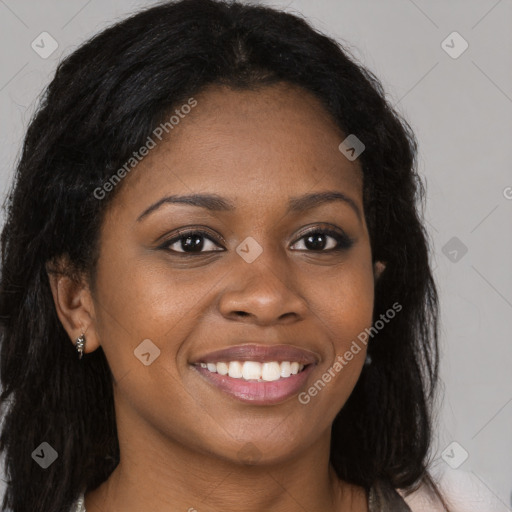 Joyful black young-adult female with long  brown hair and brown eyes