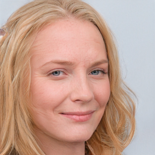 Joyful white young-adult female with long  blond hair and blue eyes