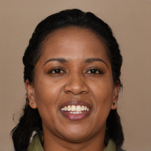 Joyful black adult female with long  black hair and brown eyes