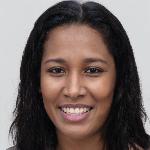 Joyful latino young-adult female with long  black hair and brown eyes
