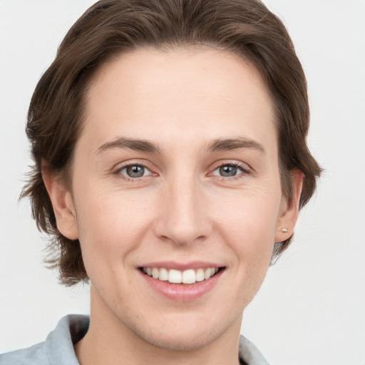 Joyful white young-adult female with medium  brown hair and grey eyes