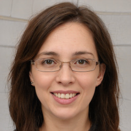 Joyful white adult female with long  brown hair and brown eyes