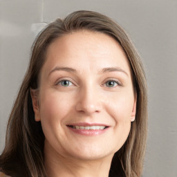 Joyful white young-adult female with long  brown hair and grey eyes