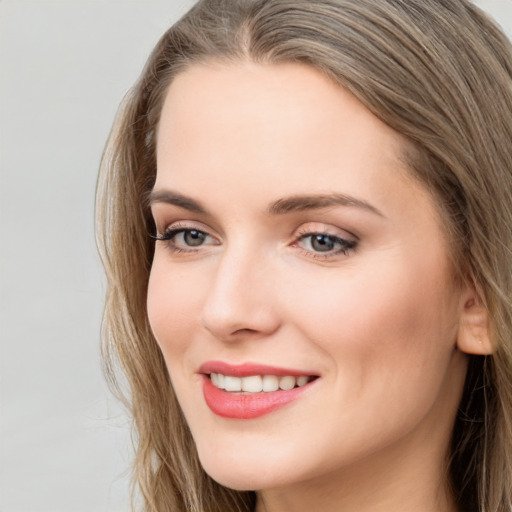 Joyful white young-adult female with long  brown hair and grey eyes