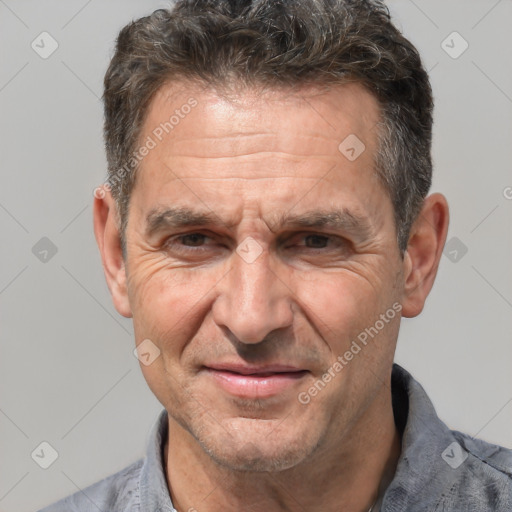 Joyful white middle-aged male with short  brown hair and brown eyes