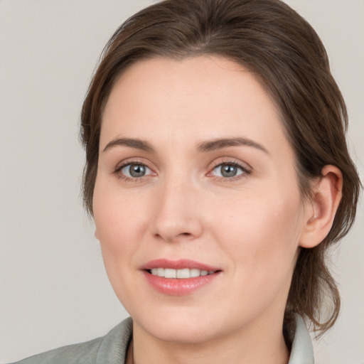 Joyful white young-adult female with medium  brown hair and grey eyes