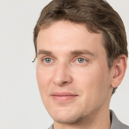 Joyful white adult male with short  brown hair and grey eyes