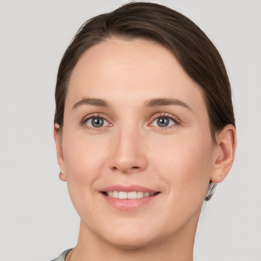 Joyful white young-adult female with short  brown hair and grey eyes