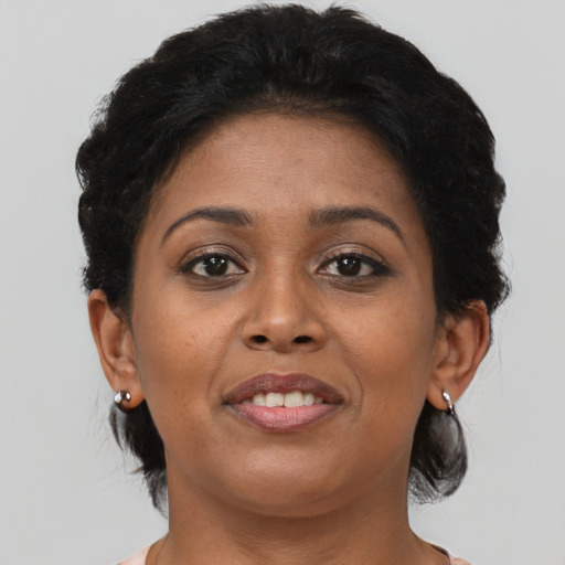 Joyful black young-adult female with short  brown hair and brown eyes