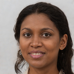 Joyful black adult female with long  brown hair and brown eyes