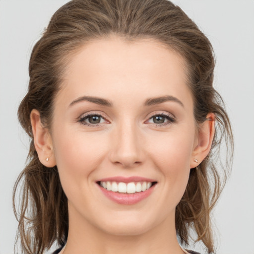 Joyful white young-adult female with long  brown hair and grey eyes