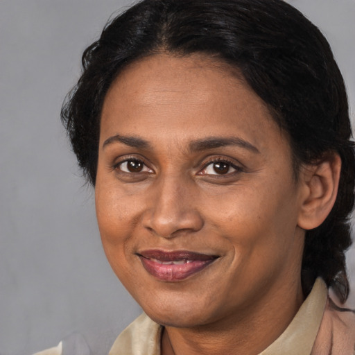 Joyful latino adult female with medium  brown hair and brown eyes
