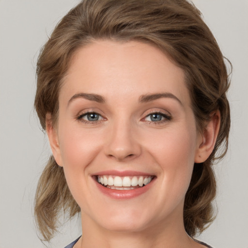 Joyful white young-adult female with medium  brown hair and green eyes