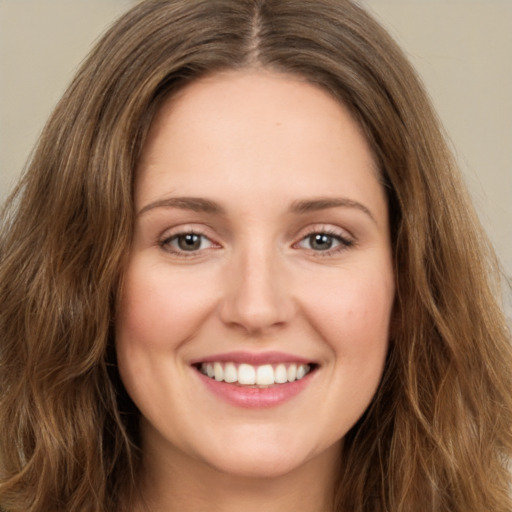 Joyful white young-adult female with long  brown hair and green eyes