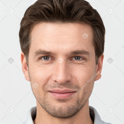 Joyful white young-adult male with short  brown hair and grey eyes