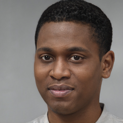 Joyful black young-adult male with short  brown hair and brown eyes