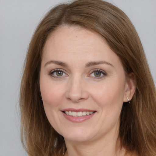 Joyful white adult female with long  brown hair and brown eyes