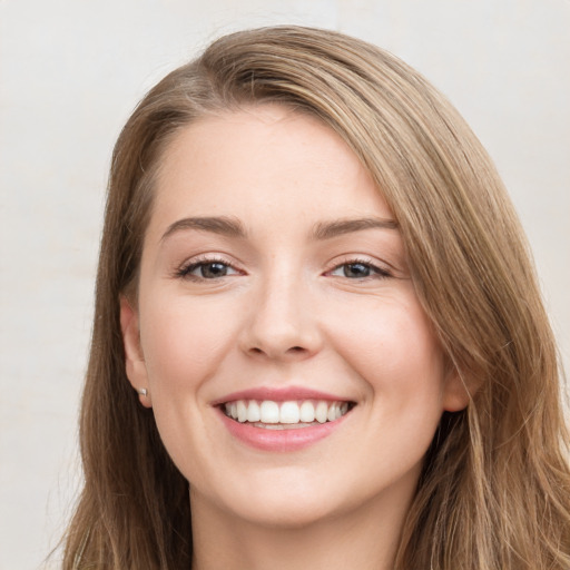 Joyful white young-adult female with long  brown hair and grey eyes