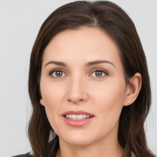 Joyful white young-adult female with long  brown hair and brown eyes