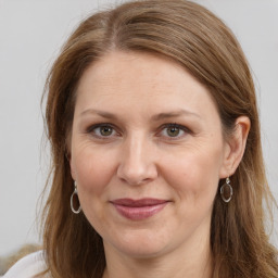 Joyful white adult female with long  brown hair and brown eyes