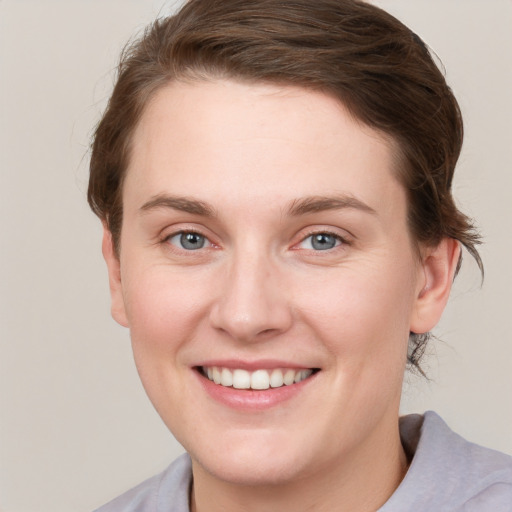 Joyful white young-adult female with short  brown hair and grey eyes