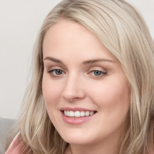 Joyful white young-adult female with long  brown hair and blue eyes