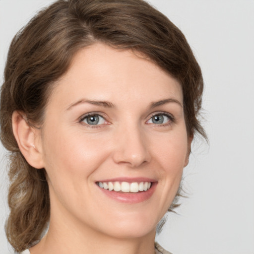 Joyful white young-adult female with medium  brown hair and green eyes