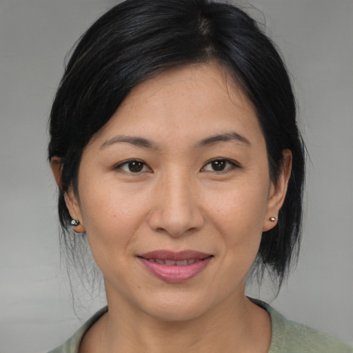 Joyful asian adult female with medium  brown hair and brown eyes