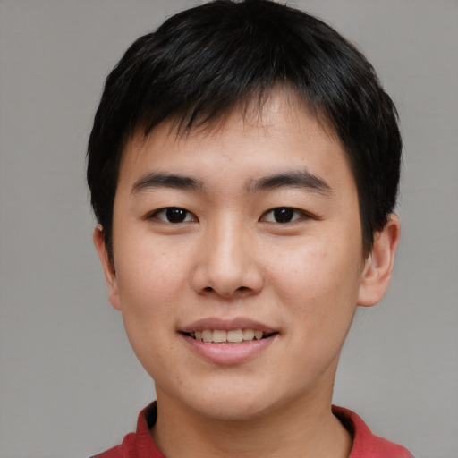 Joyful asian young-adult male with short  brown hair and brown eyes