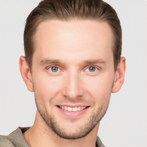 Joyful white young-adult male with short  brown hair and grey eyes