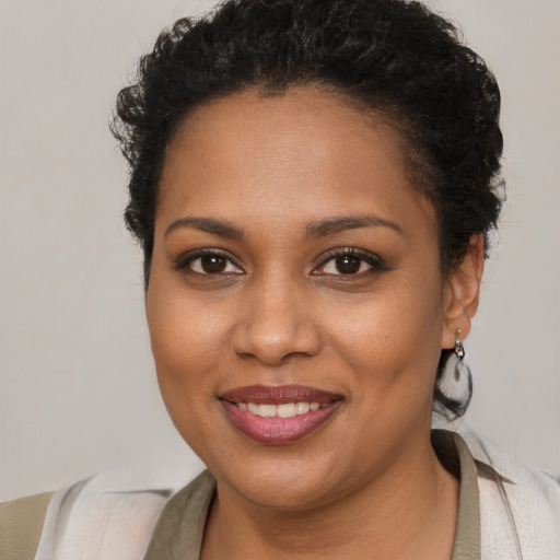 Joyful black young-adult female with short  brown hair and brown eyes