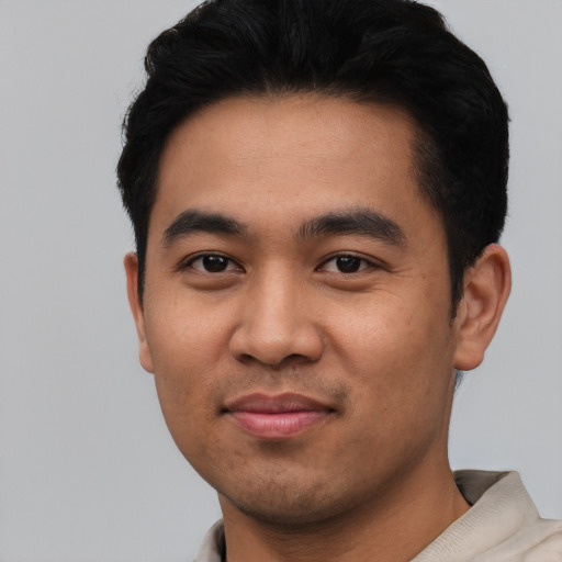 Joyful latino young-adult male with short  black hair and brown eyes